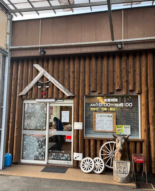 ログハウス風の温かみのある直売所の入り口と営業時間案内
